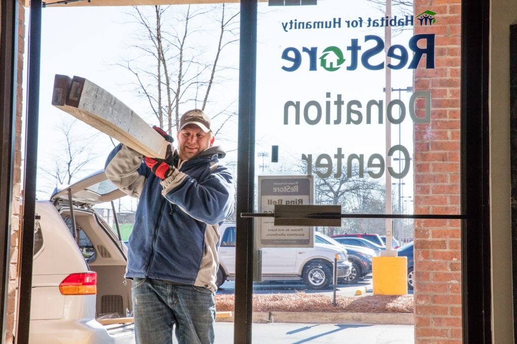 LCHFH Restore in Collinsville, IL - man brings spare lumber into facility to donate