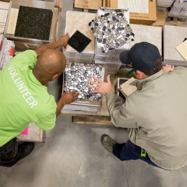 LCHFH Restore in Collinsville, IL - volunteers examining decorative stone flooring tiles